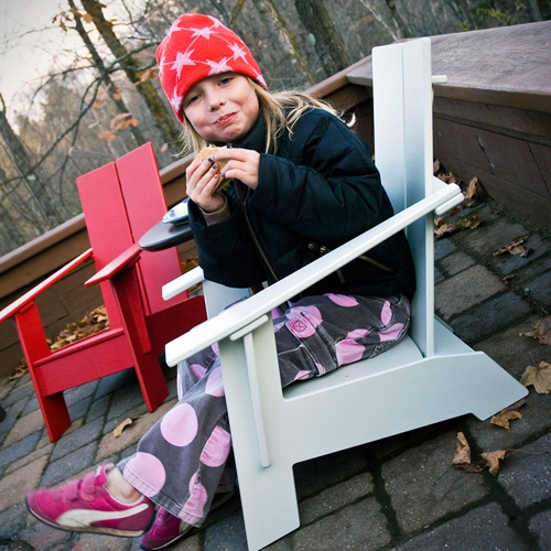 Niña disfrutando su sillon adirondack de exterior tamaño infantil